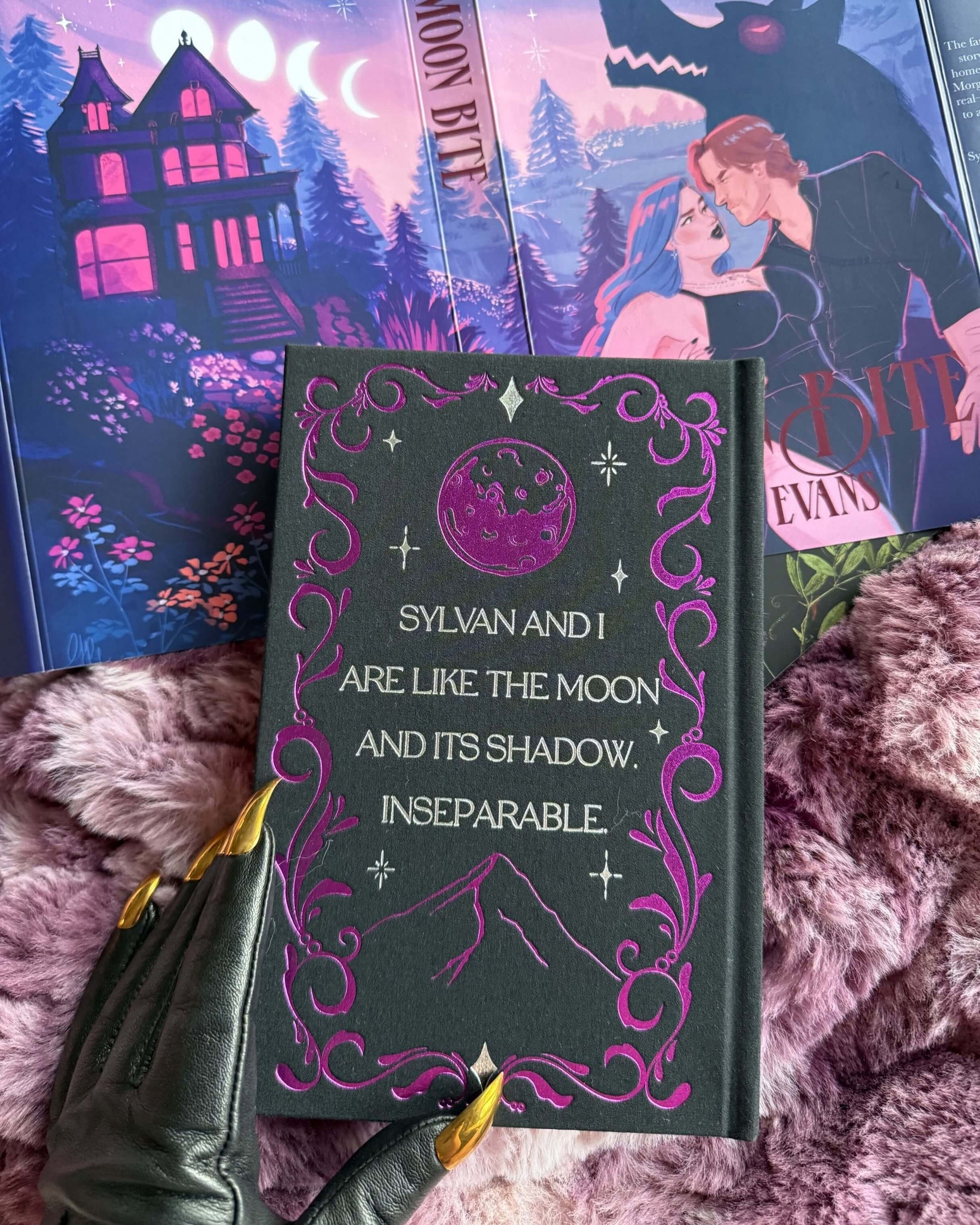 Book with decorative cover and quote, surrounded by other books on a textured surface